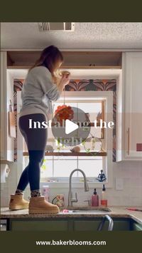 Meg | DIY + colorful eclectic decor on Instagram: "It’s a little ball of sunshine 🥹
The orange light fixture got the majority of votes and I’m SO glad it did because look at how perfect it is. I also added some of the leftover wallpaper around the window and it just pops even more.
Next up: adding an arch over the sink."