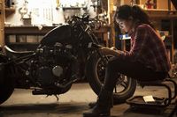 Female mechanic working on motorcycle in workshop