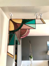 One of my newest original stained glass designs, this corner piece takes its inspiration from the eye catching Art Deco era.  While intended to be displayed in a corner (doorway or entryway), the Ava Design is also lovely backlit in a window or hung on the wall. Two rings at the top provide for convenient and secure hanging. If hanging from the ceiling, it is recommended to use cup ceiling wall thread hooks since the attached hooks are enclosed loops. *This set of two Ava Design corner pieces ha