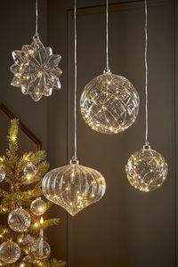 With a glittering array of clear glass and soft trailing lights, compose a look that will sparkle through Christmas and glow into the new year. Iridescent glass baubles, giant glass drops and traditional tree candles reflect against the soft pine with an array of warming lights for an exquisite Christmas atmosphere full of festive sparkle. 