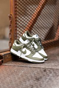 The Nike women’s Dunk Low ‘Medium Olive’ dresses the archival hoops shoe in traditional two-tone color blocking redolent of the model’s introductory ‘Be True to Your School’ series from 1985. The all-leather upper merges a crisp white base with olive green overlays and a color-matched Swoosh. Underpinning the sneaker is a traditional rubber cupsole, featuring white sidewalls that contain a lightweight foam wedge for a cushioned ride. Underfoot, the olive rubber outsole utilizes a traction patter