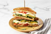 We added cucumber and greens to the tomato to make this cucumber caprese sandwich flavored with pesto, fresh mozzarella and a sweet balsamic glaze.