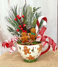 This Sweet Gingerbread ceramic mug is perfect for the holiday season! It has a sweet gingerbread family with lots of greenery,  embellishments and a peppermint stripe and polka dot ribbon to complete the look.  This is a sweet addition to your holiday decorating for years to come.    Measures approximately 8" W x 10" H