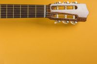 Head of classical acoustic guitar on yellow background Free Photo