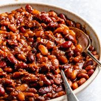 Delicious homemade slow cooker baked beans even better than the ones you grew up on! This easy baked beans recipe uses three types of canned beans, is perfectly sweet with a kick of heat if you'd like, and is easily made vegetarian. Add them to nachos or quesadillas, serve them as a dip and more! #bakedbeans #slowcooker #crockpot #sidedish #fourthofjuly #gameday