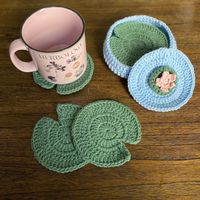 Crochet coaster set of four lily pads with pond coaster basket and water lily lid.