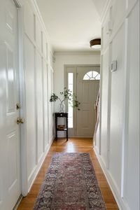 Board and batten, simply white paint, a small little table and a plant is the recipe for a perfect small entryway!