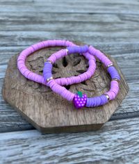 This listing is for a set of two heishi clay bead bracelets. They have two shades of purple with gold accents and a centerpiece grape charm.