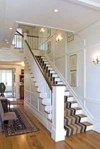 Chesapeake House: Foyer stair. The interior first floor walls are fully covered in raised paneling. Design by Purple Cherry Architects.