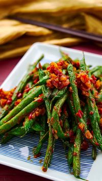 A plate of vibrant green beans stir-fried with chili garlic sauce. An easy 3 ingredient Chinese stir fry.