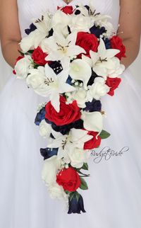 This stunning brides bouquet is a cascading bouquet made with white lilies, white calla lilies, marine blue, red and white roses accented with babies breath and pearls. This bouquet is approx 10 inches wide and 15 inches long.