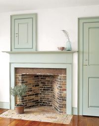 Pale Soft Green Paint used on the Fireplace Wood  Surround and Doors. A potted Topiary dresses the Hearth and a Blue Tint Bottle with a Feather dresses the Mantle.