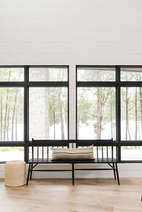 Black windows with bench in modern cabin on a lake - Studio McGee Design