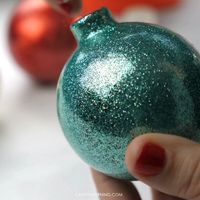 Here’s a fun Christmas craft to make with the kids or your adult friends! Make DIY glitter ornaments to hang on the tree. Turn clear ornaments into glitter ones. Christmas craft art project for kids.