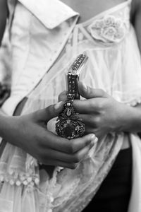 A softly boned, deconstructed heirloom corset in shredded floral jacquard, washed organza and embroidered silk tulle is worn with a silver four-ring clutch.