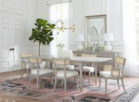 Crafting the perfect dining room ambiance: a centerpiece table, a set of inviting chairs, and chic storage for a seamless blend of functionality and aesthetics. Pictured here are the Bertam Dining Table, the Marshall Chair Collection, and the Vivian 8-Drawer all in the Soft Gray finish.