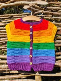 Rainbow Crochet Kids Cardigan - pure joy in a cardigan! Cap sleeve for versatlity, buttons unfasten for ease of dressing. Every piece I make is unique, there is no other cardigan exactly like this in the world! Handmade with love, care and attention to detail. Details 100% Premium Acrylic Yarn (vegan) Wooden Buttons Relaxed Fit 33cm length 66cm chest circumference Wash at 30 degree gentle cycle Tumble dry cool or dry flat SAFETY: Please regularly check that buttons are secure to avoid choking