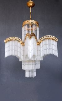 This beautiful chandelier lamp will make a statement in your home and gives a beautiful effect. This lamp was most likely made in Turkey. The sticks are hollow glass. They make a gentle sound if they get caught in a breeze. The lamp is white with gold, it is pictured with warm-colored light bulbs hence the change of color, it would stay white with white light bulbs. It is 35 1/2'' (90 cm) high and has a diameter of 23'' (45 cm) wide, a great piece for a room with a high ceiling. This is a vintage piece and might show small damages and patina,  but all in all in great vintage condition. Works with 5 E14 and 1 E27 lightbulbs. Please note that the glass sticks will be removed for safe shipment, they are very easy to reattach but it will be quite a a bit of a task as there are 445 sticks, this