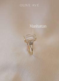 14K Yellow Gold | Manhattan features a 10x5mm baguette shape center stone with baguette and round accent stones set in bar prongs on a unique split shank.