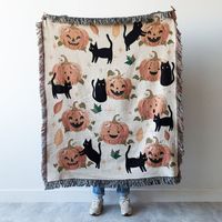 "Get ready to add a touch of spooky fun to your home decor with this cozy 100% cotton throw blanket! Featuring cute and cheeky orange pumpkins and black cats on an off-white background, this blanket is perfect for adding a festive touch to your Halloween decor. The colorful pattern is woven with colored threads, not printed, so it is sure to last through many seasons of festive fun. This blanket makes a great gift for any cat or Halloween lover, young or old. Wrap up in warmth and comfort with t