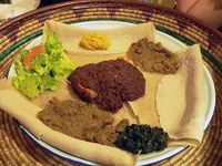 🇪🇹Wiki: Ethiopian Cuisine: Injera, wat (very spicy meat - several kinds shown) & vegetables. Wat, a thick stew, is served atop injera, a large fermented teff sourdough flatbread (50cm diameter.) Ethiopians eat exclusively with their right hands, using pieces of injera to pick up bites of entrées & side dishes. - Wikipedia