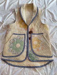 This is a handmade vest from a vintage hand pieced and hand quilted Grandmothers Garden quilt. Lovely butter yellow. The vest is a Small: Medium with a 37 inch chest and 39 inch hip. Nice sized hand warmer pockets. Roll over lapel collar. A beautifully upcycled handmade piece.