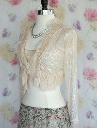 Y2k Betsey Johnson Sheer Peach Ivory Heavily Ruffled, Beaded and Sequin Bolero Jacket with stunning Iridescent White Sequins throughout, with spectacular sunburst of Sequin on back, and multi levels of gauzey ruffles. The sleeves and Bottom of the jacket on the back are edged with beading. There is one hook closure at the center of the vneck. So utterly whimsical and feminine, A color that will go with just about anything. Beautiful as shown with a vintage Boho skirt, with a pair of jeans, over a silky slip or dress. Such a subtle and wonderful piece to keep in your closet.  ITEM DETAILS AND MEASUREMENTS: LABEL: Betsey Johnson Size Tag: M/L but will work for a smaller woman as well.  Shoulders: 5 Pit to Pit Closed: Approx 23" Arm Pit Opening: 8.5 Sleeve Length: 19.5" Length in Front: 13" L