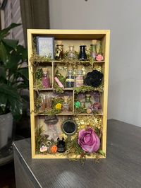 Handmade mini witch apothecary shelf! Perfect to add to your living room or bedroom decor. Would even look amazing on your altar since I have included 2 bottles with crystals. The crystal chips included are rose quartz and black obsidian. It is said that pairing these crystals purge negative emotions and keep you feeling safe. All items are glued to the shelf so nothing moves around.  *If you would like one custom made, feel free to send me a message and we can work it out! Measurements: Height: