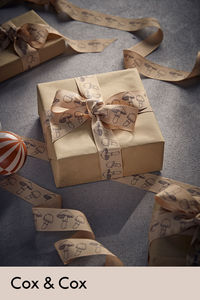 
Planted on a light brown ribbon, hand-drawn mushrooms sit along the ribbon in a repeated pattern for a design that is minimal but brings the upmost sophistication to your gift wrap.  

The cute and quaint design is slightly raised from the ribbon itself, creating textural detailing and enhancing the finish.

Exclusive to Cox & Cox, this ribbon is offered in a generous 15 metres, so is sure to last you through the whole festive season. 
