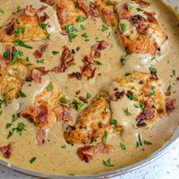 This Southern Smothered Chicken Recipe is comfort food at its best. It features crisp bacon, lightly breaded chicken breasts, and lusciously creamy seasoned gravy made from common pantry spices. 