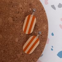 These stylish earrings are handmade from polymer clay making them lightweight and easy to wear. Choose from lilac and green, or orange and beige stripes. Approx 4 cm. With stainless steel ball studs.