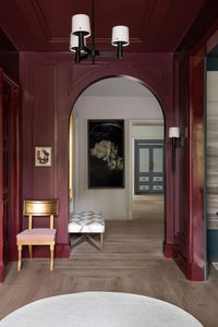 entrance hall savage immersed the foyer in preference red by farrow ball, creating a dramatic entry the hallway connects the open dining lounge and powder room to the rest of the home chair antique, in s harris fabric art jennifer gibbs over chair, joseph guay in hallway