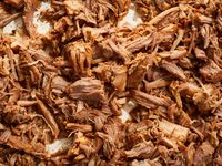 Instant Pot carnitas made by pressure-cooking pork shoulder with onion, garlic, orange, and spices for a mouthwateringly delicious taco filling.