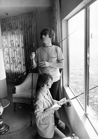 john lennon & ringo starr fishing from their hotel room in seattle, august 1964