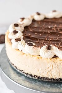 Espresso Cheesecake is the perfect dessert for coffee and chocolate lovers! Rich, silky espresso cheesecake sits on an OREO crust and is topped with chocolate ganache, cream cheese frosting swirl, chocolate shavings and espresso beans! Delish! // Mom On Timeout #cheesecake #dessert #baking #espresso #coffee