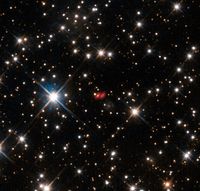 This image from the NASA/ESA Hubble Space Telescope shows the distant active galaxy PKG 1830-211. It shows up as an unremarkable looking star-like object, hard to spot among the many much closer real stars in this picture. Recent ALMA observations show both components of this distant gravitational lens and are marked in red on this composite picture.