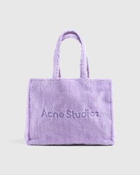 Shell is 100% polyester. Furry fleece finish. Lining is 95% cotton and 5% acrylic. Contrast is 100% calf leather. Two shoulder strap handles and two short straps. Small zip interior pocket. Embossed Acne Studios logo at the face.