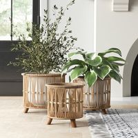 Raised baskets, like this 3-piece set, are always an attention-getter in any setting. This trio of beige and brown bamboo baskets are designed to hold a variety of potted plants. Each basket sits on three bold, tapered, tripod-style feet that add crisp contrast against the airy, open round silhouettes up top. Perfect for holding potted plants, shoes, blankets, and more, this set is nestable when not in use for convenient storage. The small basket measures just over 11" tall, the middle basket is