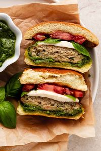 Packed with the flavors of parmesan cheese, Italian seasoning, and fresh basil, these caprese pesto chicken burgers are the most flavorful chicken burgers I've ever had. Top with fresh mozzarella cheese, a slice of juicy tomato, and a generous dollop of basil pesto for a summery burger. Recipe on sallysbakingaddiction.com