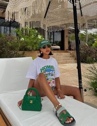 Get inspired for your Miami vacation with our guide featuring 8 casual summer outfits! Whether you're hitting the beach or enjoying a leisurely brunch, these outfits are designed to keep you looking cute and comfortable. Perfect for soaking up the South Beach sun, this cool look with a graphic tee, a green Chanel Kelly bag and green Hermes Chypre sandals is definitely worth recreating!