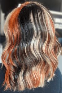 Unleash your inner wild child with a three-toned hair color treatment that blends dark, light, and fiery hues for a bold and eye-catching style.