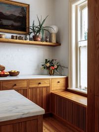 The second floor of this historic brick building was originally divided into two small rental apartments. The project involved creating a new large kitchen, living room and dining room. When construction began, the original wide plank heart pine floors were uncovered. The kitchen millwork, with nickel gap detailing, was finished to reflect the character of the wood.