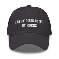 "Easily Distracted By Rocks Hat, Geology, Geology Hat, Geology Gifts, Geologist Student, Geology Student Gifts, Dad Hat Adjustable Cap Dad hats aren't just for dads. This one's got a low profile with an adjustable strap and curved visor. * 100% chino cotton twill * Green Camo color is 35% chino cotton twill, 65% polyester * Unstructured, 6-panel, low-profile * 6 embroidered eyelets * 3 ⅛\" (7.6 cm) crown * Adjustable strap with antique buckle * Blank product sourced from Vietnam or Bangladesh"