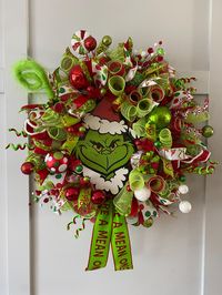 This amazing Grinch 💚 wreath is soooo beautiful, more beautiful in person.  Mr Grinch is ALIVE, it will light up your door, room and put a SMILE on everyone who is going to pass beside it. He is large and bold!  Measures 24" diameterand 8¨inch deep it is full wreath. Packed full of festive goodies and  Wreath covered with DecoMesh, beautiful ribbons, filled with whimsical glittered picks, lollipops, baubles, christmas tree picks, gifts and more. The center of attention is this large christmas G