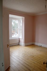 Empty pink room with wood floorboards in Victorian House