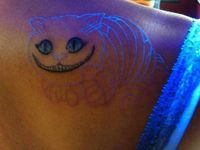 Cheshire Cat black ink tattoo.