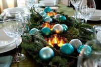 table runner made of evergreens, candle votives and turquoise ornaments