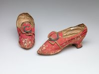 Pair of woman's hsoes, 1770s-1780s. Red ribbed silk with floral silk embroidery and cast metal buckle.