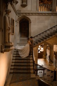 An intimate and atmospheric wedding at London wedding venue, Ashridge House. Ashridge house in London is one of the most beautiful and historic UK wedding venues, being a former residence of Henry 8th. A long pink table with pink florals and neutral candles in the grand hall, with dried floral installation. A winter wedding with snow, and couple posing in Ashridge House grand Staircase. bride wearing an embellished strapless Gahlia Lahav gown from London Bridal boutique, Browns Bride. Atmospheric and romantic wedding photography by London wedding photographer Esme Whiteside Photography