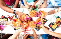 Stock Image: Friends toasting tropical drinks